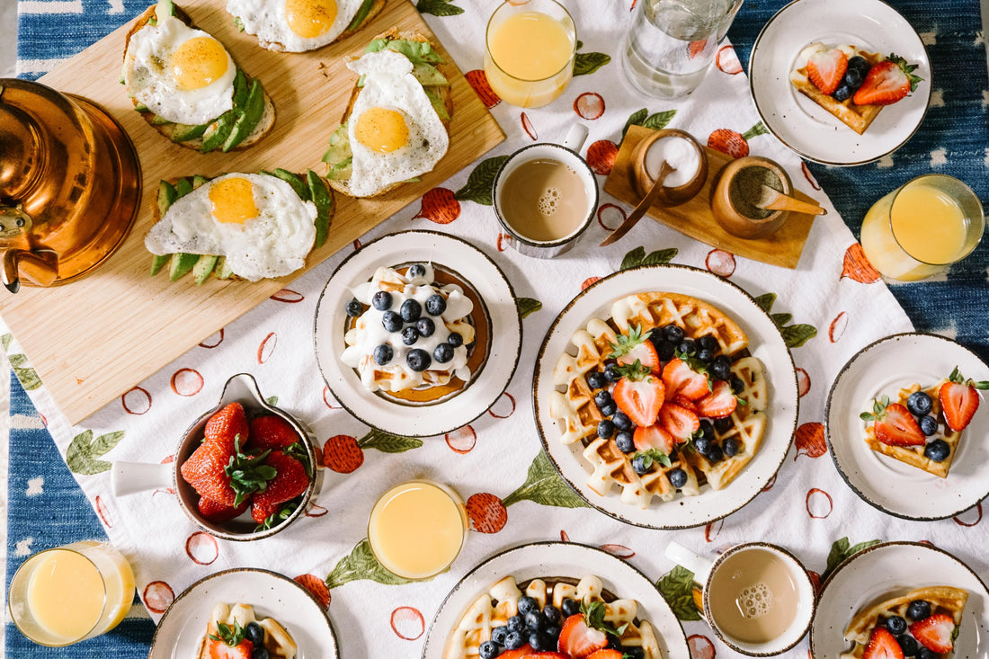 Intuitive Eating, table of breakfast foods such as pancakes, waffles, avocado toast, eggs, fruits, orange juice, and coffee