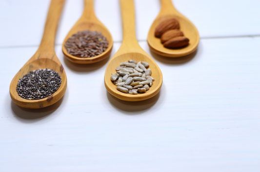 Spoons of protein-rich foods such as nuts (pine nuts, almonds) and seeds (chia seeds, flax seeds)