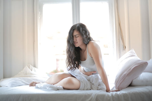 Woman suffering from gut pain in bed