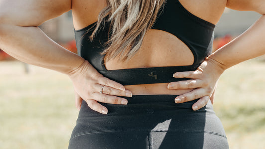 Girl holding her back due to muscle pain and soreness