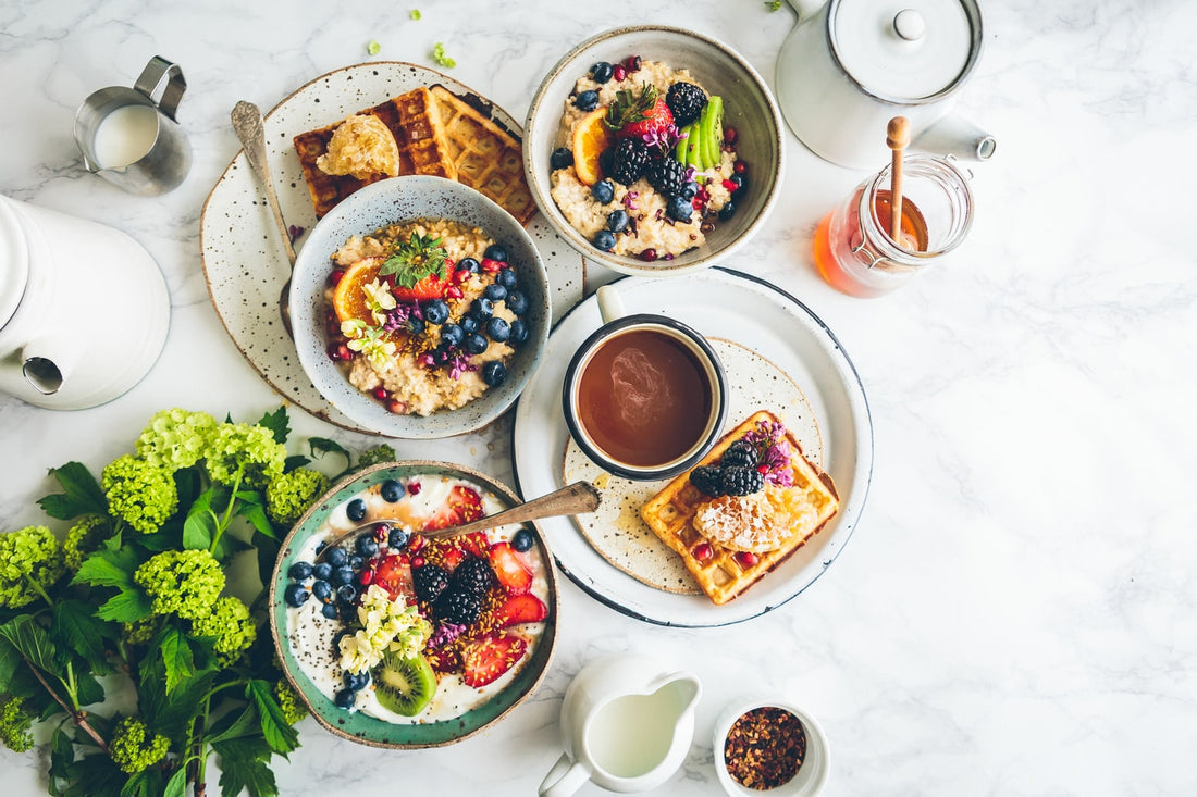 Food sensitivity, table with breakfsat foods such as oatmeal, fruit, waffles, chia pudding, cream, butter, coffee, and honey