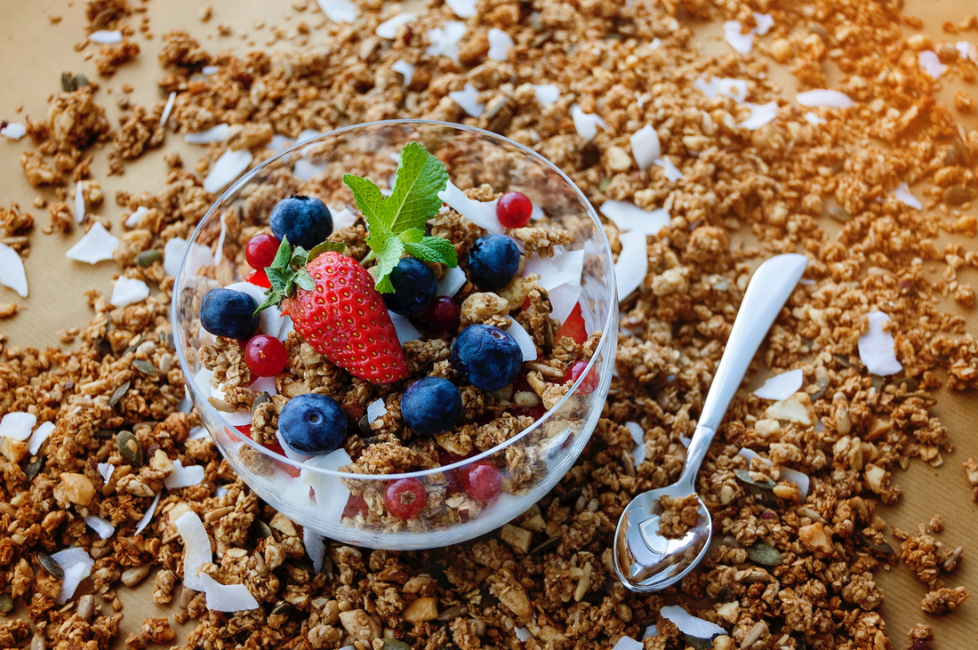 Yogurt granola bowl with fruits like blueberries, strawberries, and coconuts