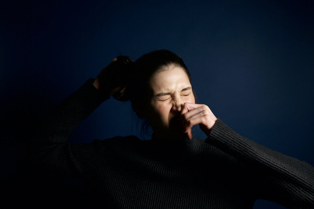 Woman sneezing and blowing her nose